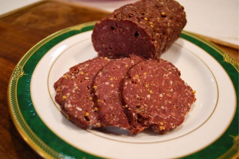 Slicing homemade venison salami after baking.