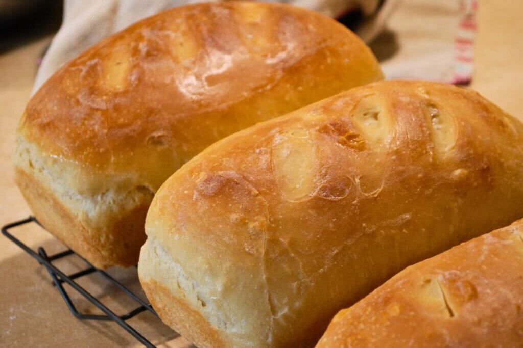 Fresh homemade bread loaves, often served with butter or tallow