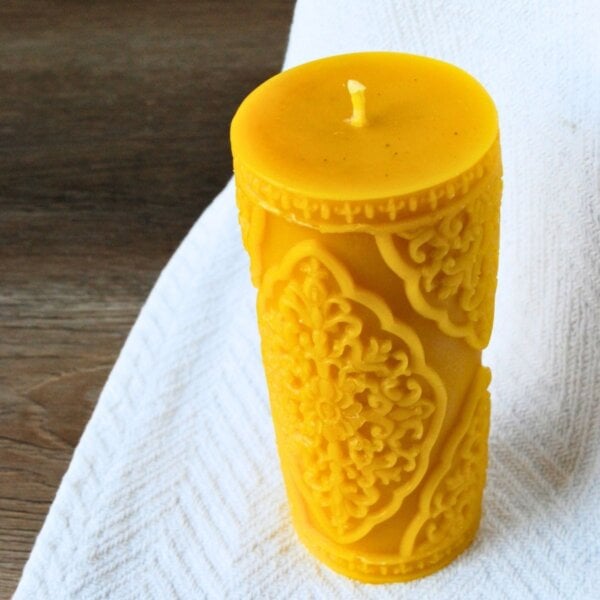 Large beeswax pillar candle displayed on white cloth