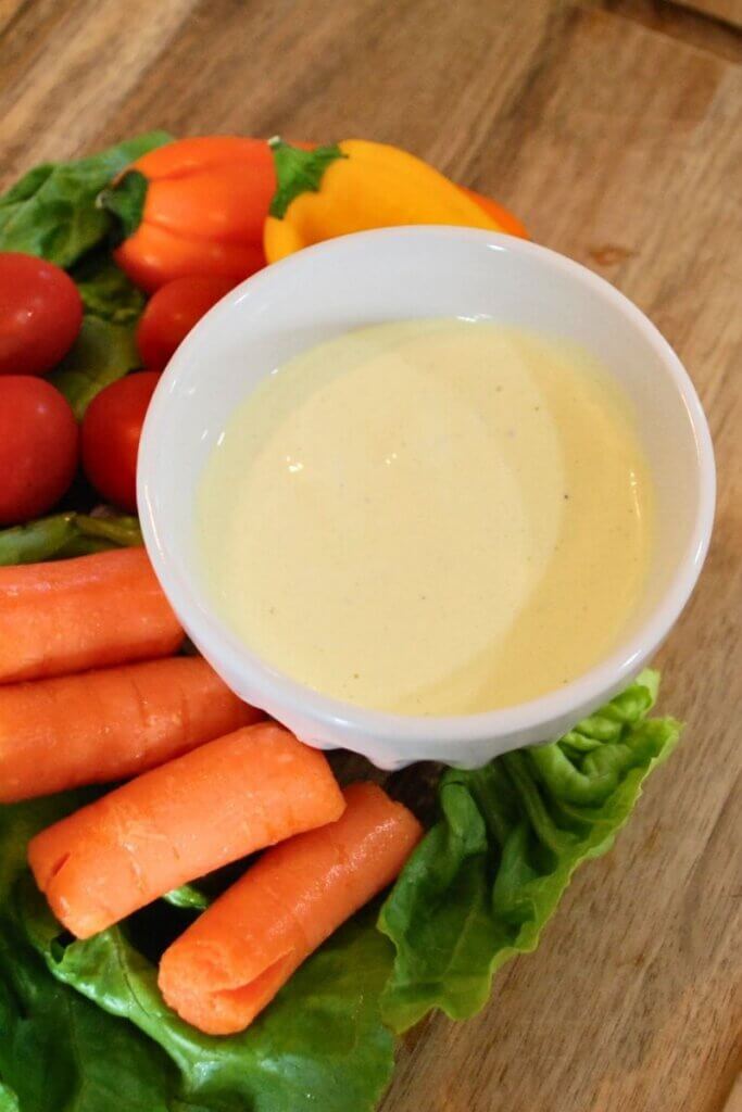 Close-up of creamy homemade garlic dip in a white bowl.